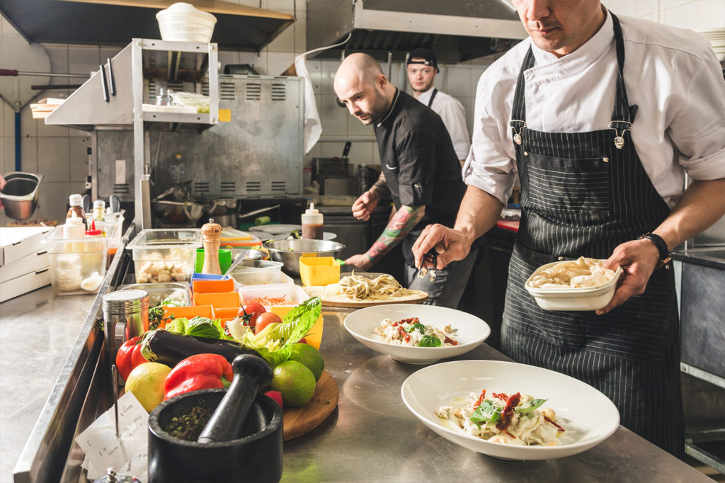 chefs preparing food in a kitchen