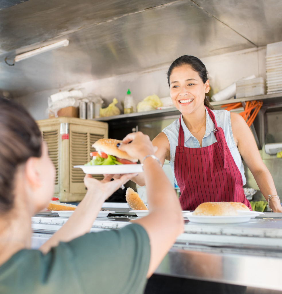 food truck owner handing a customer food