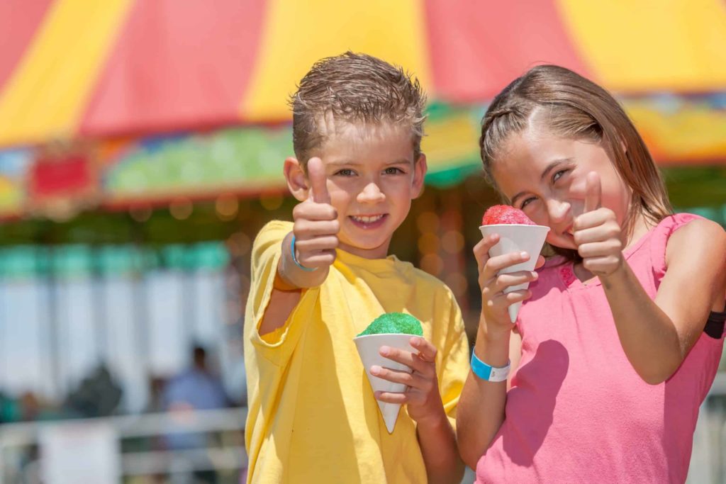Kids eating snow cones at a festival