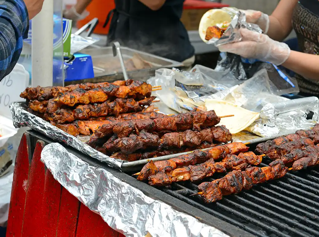 Meat on skewers grilled by a food vendor